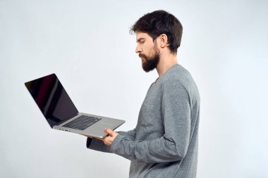 Gri kazaklı bir adam dizüstü bilgisayarlı. Yaşam tarzı teknoloji iletişimi internet işi yapıyor.