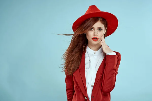 Belle femme en chapeau rouge veste lèvres rouges longs cheveux charme fond bleu — Photo