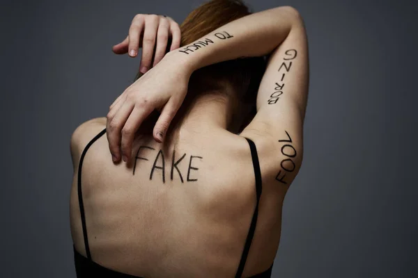 Kvinna med inskriptioner på kroppen frustration och missnöje känslor livsstil grå bakgrund — Stockfoto