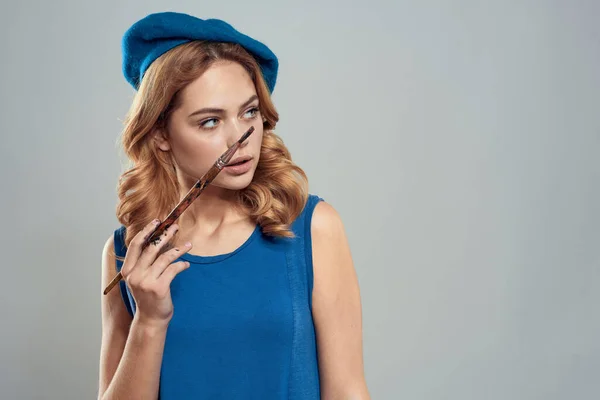 Kvinna konstnär borste i handen blå basker klänning hobby konst livsstil ljus bakgrund — Stockfoto