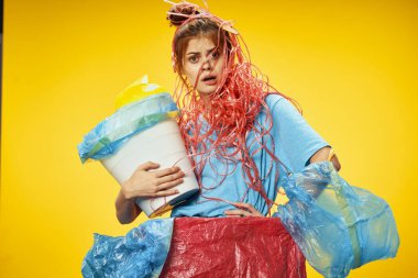 Elinde bir kova olan öfkeli kadın. Çok renkli paketler.