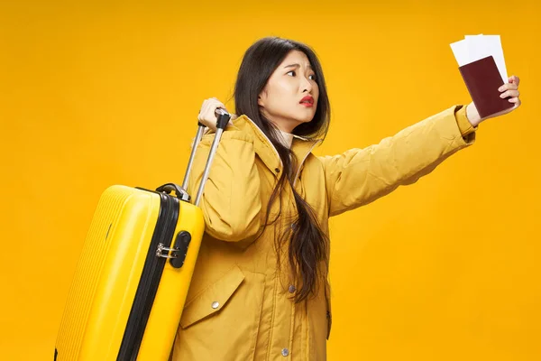 Une femme asiatique parcourt le monde avec une valise et un passeport — Photo