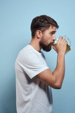 Sakallı adam bira kupası alkol beyaz tişört mavi arka plan