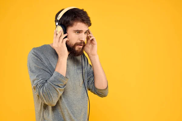Hombre en auriculares escucha música tecnología estilo de vida gente divertida fondo amarillo —  Fotos de Stock