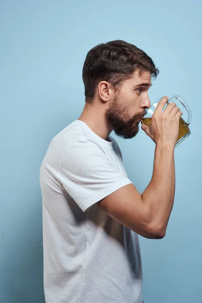 Homme barbu bière tasse alcool blanc t-shirt vue de côté fond bleu — Photo