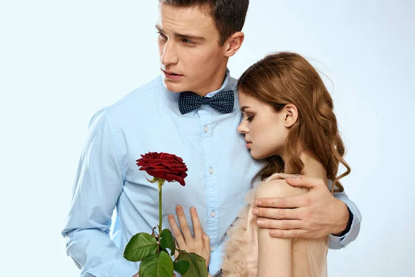 Hombre y mujer con una rosa roja sobre un fondo claro amor abrazos familiares — Foto de Stock