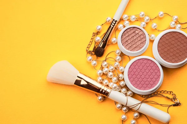 Eyeshadows and makeup brushes on a yellow background top view professional cosmetics — Stock Photo, Image