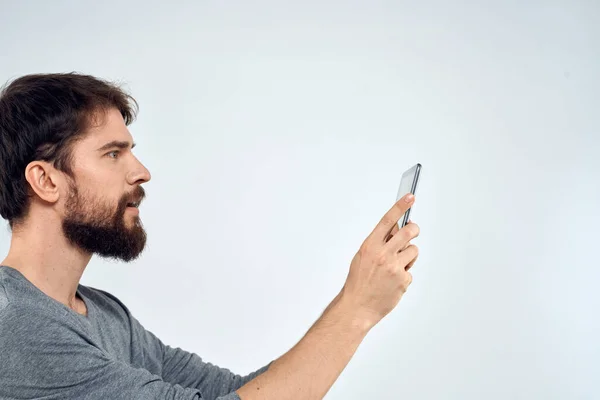 Ein Mann mit einem Tablet in der Hand Internet-Technologie Kommunikation graue Jacke heller Hintergrund — Stockfoto
