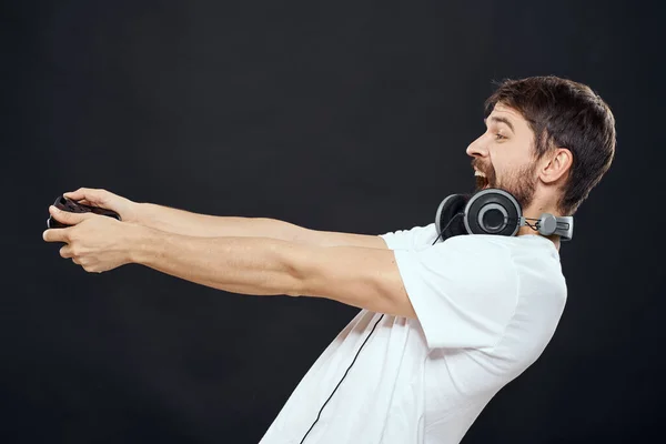 Άνθρωπος με joystick στα χέρια ακουστικά τεχνολογία ελεύθερο παιχνίδι lifestyle σκοτεινό απομονωμένο φόντο — Φωτογραφία Αρχείου