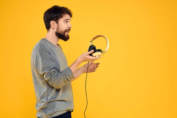 戴耳机的男人听音乐科技生活方式有趣的人黄背景 — 图库照片