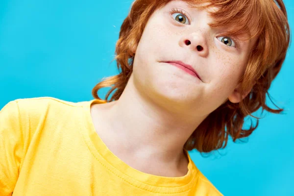 Alegre chico pelirrojo con una mirada sorprendida primer plano camiseta amarilla —  Fotos de Stock