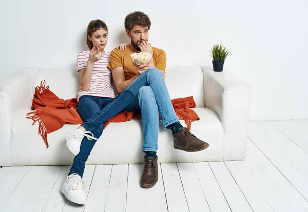 Ζευγάρι ερωτευμένο με ποπ κορν και βλέποντας τηλεόραση στον καναπέ σε εσωτερικούς χώρους — Φωτογραφία Αρχείου
