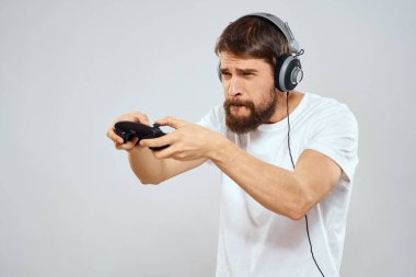 Gamepad 'li kulaklıklı bir adam hobi hayatı tarzı hafif arka planda oynuyor.