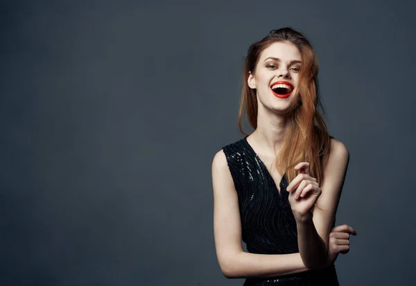 Charmant dame in zwarte jurk is gebaren met haar handen op een grijze achtergrond bijgesneden met Copy Space — Stockfoto