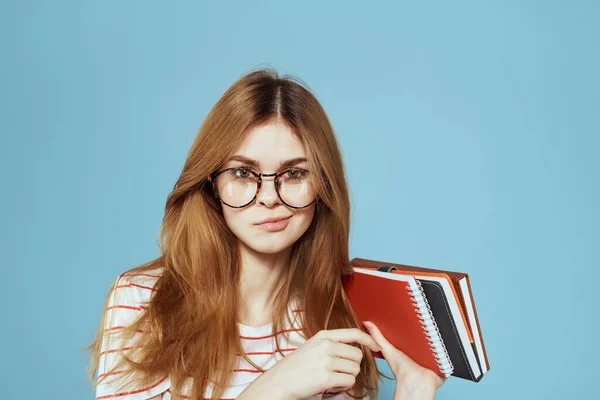 Energetic female student with notepads and glasses model blue background — Stock Photo, Image