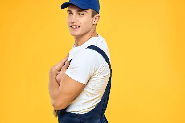 Man in het werken uniforme emoties rendering service delivery service gele achtergrond — Stockfoto