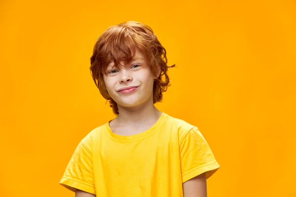 Vörös hajú fiú, aki göndör arcát egy sárga elszigetelt háttér Copy Space — Stock Fotó