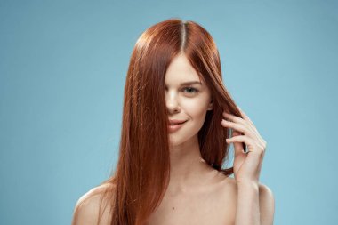 Çıplak omuzlu, uzun saçlı, bakımlı, çekici bir kadın.