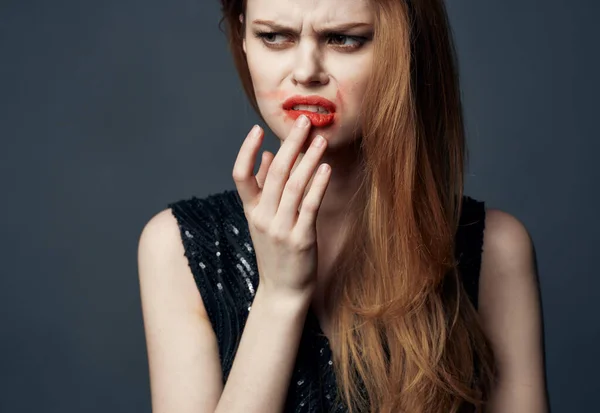 Una donna in un abito nero con labbra rosse gesti con le mani sconcertato sguardo sfondo grigio — Foto Stock