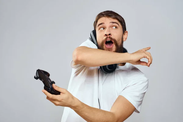 男子与游戏垫耳机播放休闲技术白色T恤背景 — 图库照片