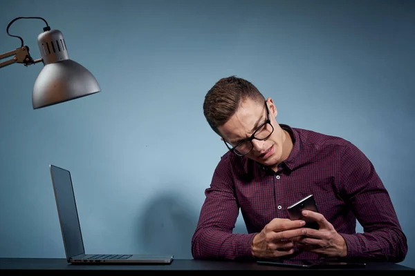En man i skjorta med en laptop vid bordet är en chef på kontoret och en lampskåpsmodell — Stockfoto