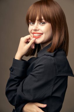 Çekici, açık tenli, şık giyimli bir bayan.