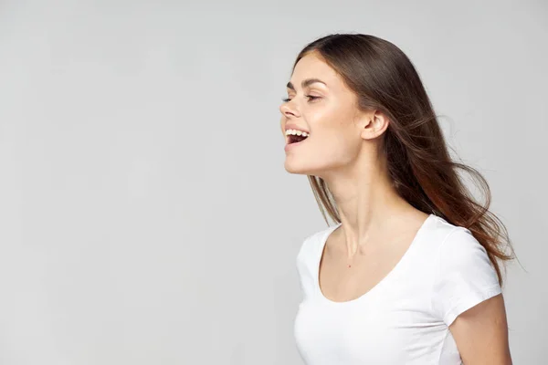 Ευτυχισμένη γυναίκα με λευκό μπλουζάκι με ανοιχτό το στόμα κοιτάζει στο πλάι — Φωτογραφία Αρχείου