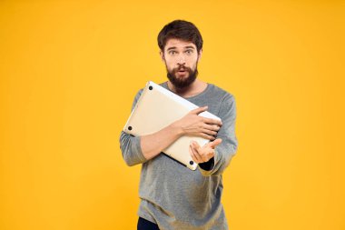 Bilgisayarlı, kablosuz teknolojili internet yaşam tarzı olan adam sarı renkli, izole bir arka plan.