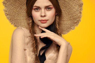 Sarı arka planda saman şapkalı portre kadın. Yazlık elbise mankeni romantizmi.