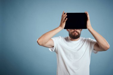 Tabletli bir adam mavi arkaplanda yüzün yanında kırpılmış görünüm dokunmatik izleme yeni teknolojileri kopyala
