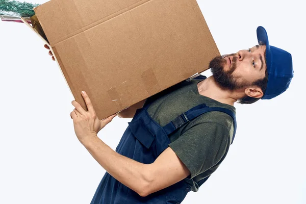 En man i arbetsuniform med en låda i händerna. — Stockfoto