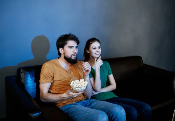 En el sofá y una mujer bonita está viendo programas de televisión — Foto de Stock