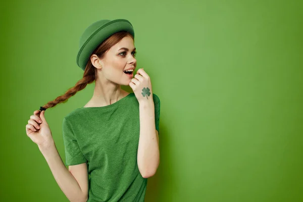Femme heureuse avec trèfle le jour de la Saint-Patricks en vêtements verts et un chapeau sur sa tête gesticulant avec ses mains — Photo