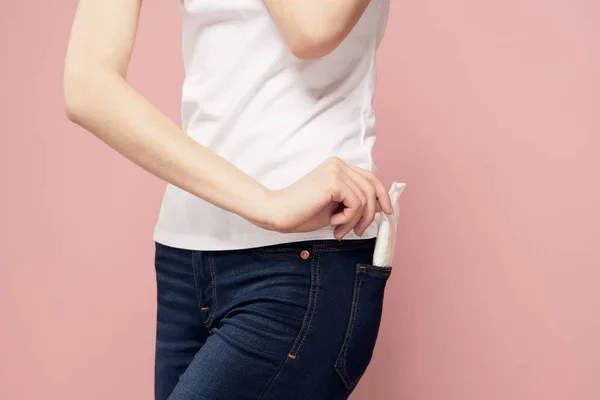 Mulher com almofada perto de jeans e agente de proteção de higiene para o ciclo menstrual — Fotografia de Stock