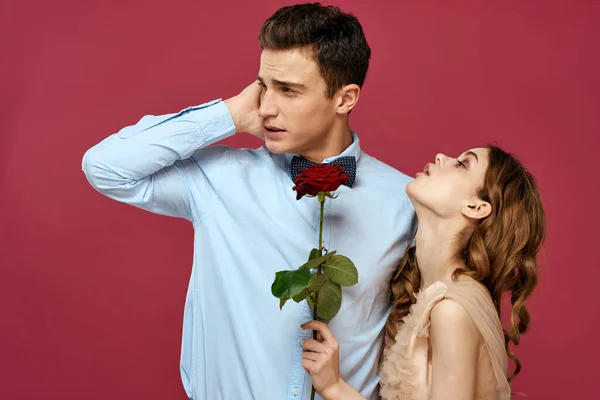 Retrato de pareja romántica enamorada de rosa roja sobre fondo aislado y traje clásico vestido de noche — Foto de Stock
