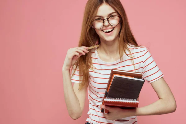 Mladá studentka s knihami na růžovém pozadí brýle na tváři vzdělávání ústav oříznutý pohled — Stock fotografie