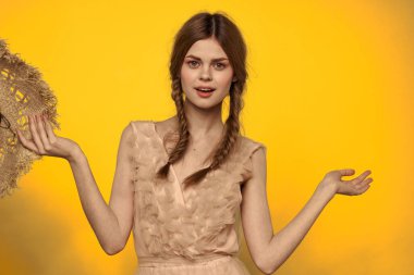 Sarı arkaplan duygularıyla elinde hasır şapkalı bir kadın... 