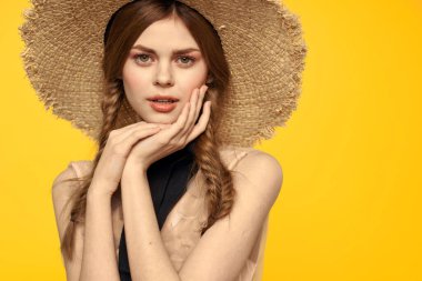 Sarı arka planda kırmızı örgülü kadın portresi.