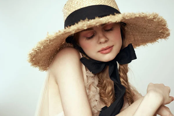 Menina bonito em chapéu de palha com fita preta e vestido no fundo luz vista cortada — Fotografia de Stock