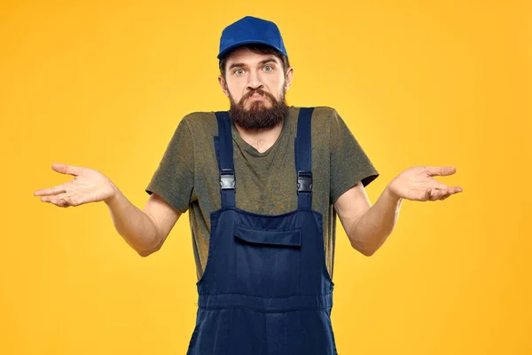 Man in work uniform rendering service forklift work lifestyle yellow background — Stock Photo, Image