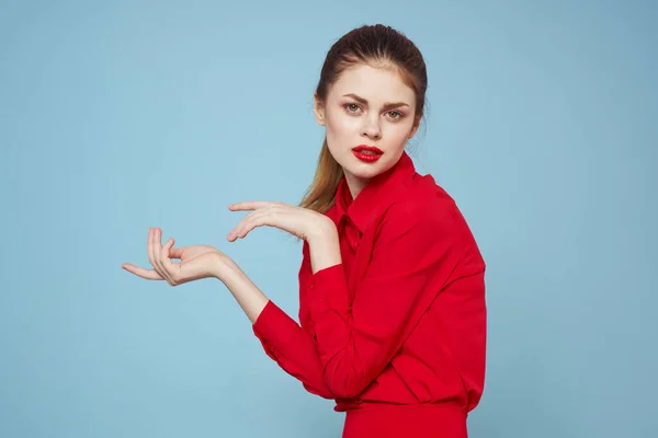 Attraktive Frau in heller Kleidung auf blauem Hintergrund gestikuliert mit Händen und roten Lippen Make-up abgeschnitten Ansicht Emotionen — Stockfoto