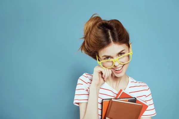 Étudiante énergique avec bloc-notes et lunettes modèle fond bleu — Photo