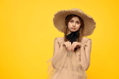 Sarı arka planda kırmızı örgülü kadın portresi.