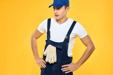 Çalışan üniformalı adam duygularını servis hizmeti sarı arka planda sunuyor