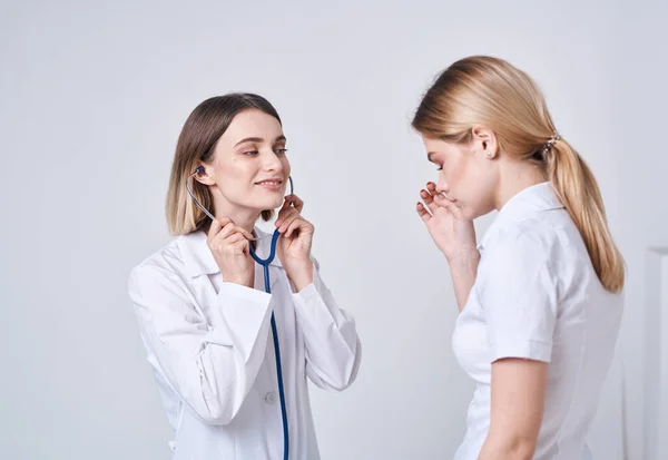 Patienten klagar till läkaren efter behag och ett blått stetoskop — Stockfoto