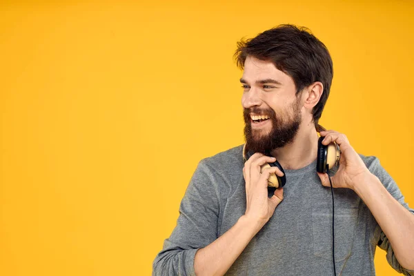 Ο άνθρωπος με ακουστικά ακούει μουσική τεχνολογία lifestyle διασκέδαση άνθρωποι κίτρινο φόντο — Φωτογραφία Αρχείου