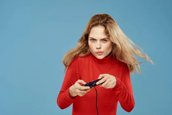 Прелестная женщина геймпад в руках, играя в игры развлекательные приставки к образу жизни синий фон красная куртка — стоковое фото