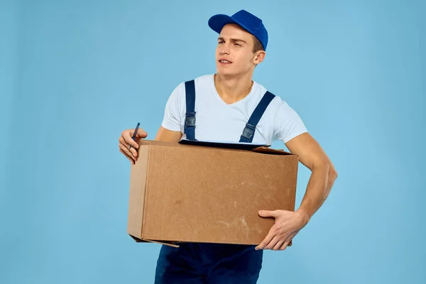 Człowiek pracownik z kartonu box dostawy ładowarka styl życia niebieski tło — Zdjęcie stockowe