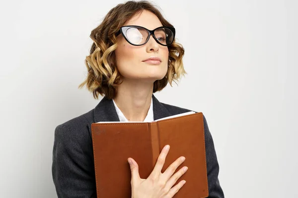 Femme d'affaires dans un costume classique avec un cahier à la main et des lunettes sur son visage Espace de copie — Photo