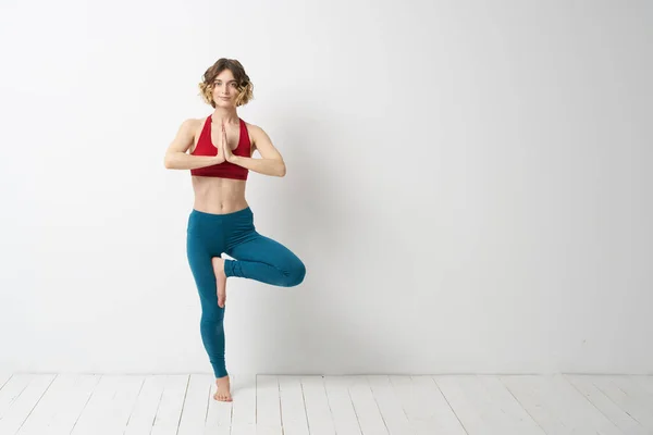 Seorang wanita dalam pertumbuhan penuh Di kamar yang cerah yoga meditasi terlibat dalam olahraga — Stok Foto